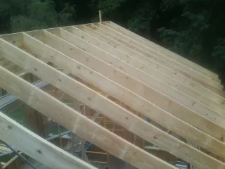 New roof rafters set over an addition before sheathing in Paynes Creek