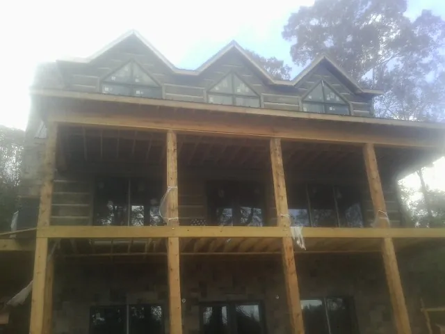 Dormers and porch framing on a large log home under construction — Roof Coating work by our crew in Paynes Creek
