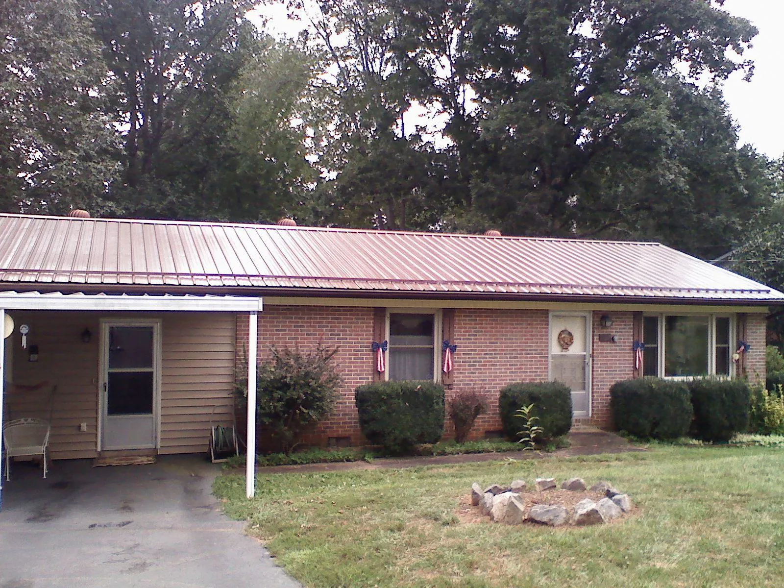 Bronze metal roof and carport on a brick ranch home — Roof Repair work by our crew in Paynes Creek