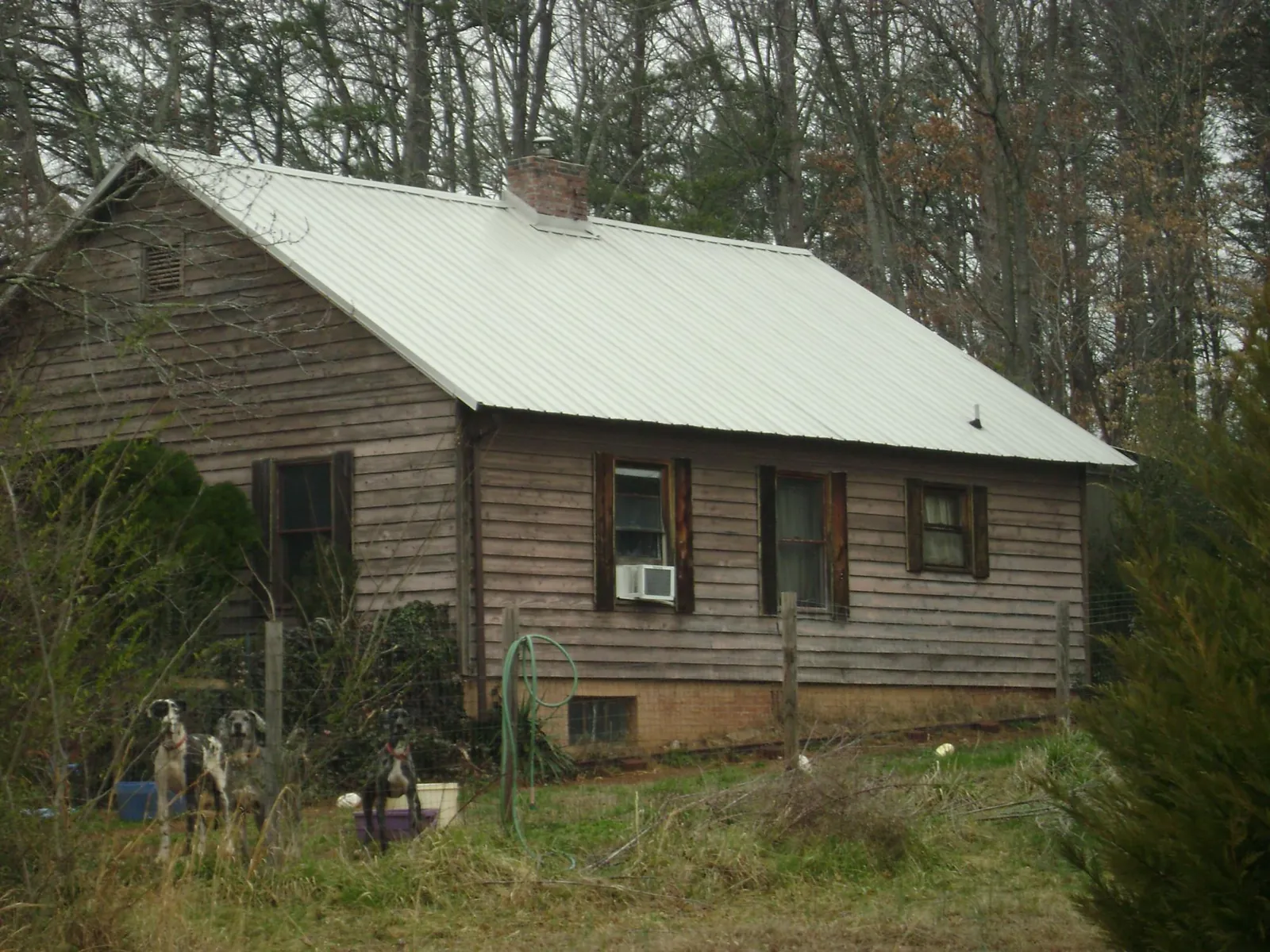 White metal roof on an old wood sided farmhouse, from a Metal Roof Installation job in Paynes Creek